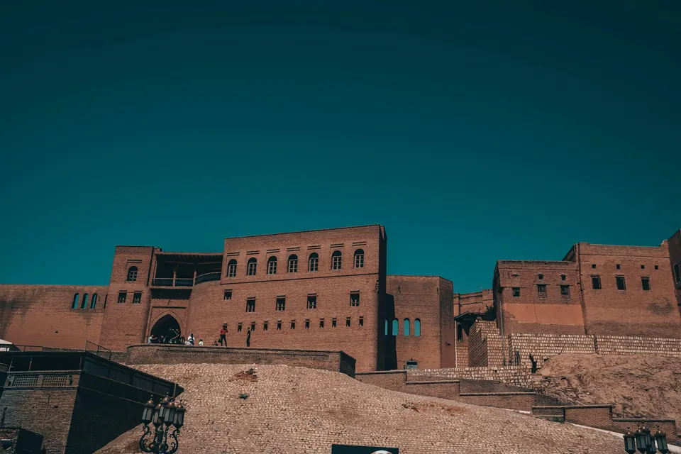 The brick walls of the Erbil Citadel under a clear blue sky