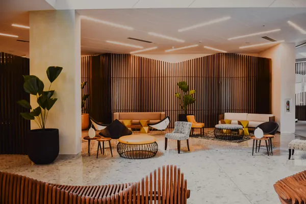 A hotel lobby lounge with armchairs and wooden walls