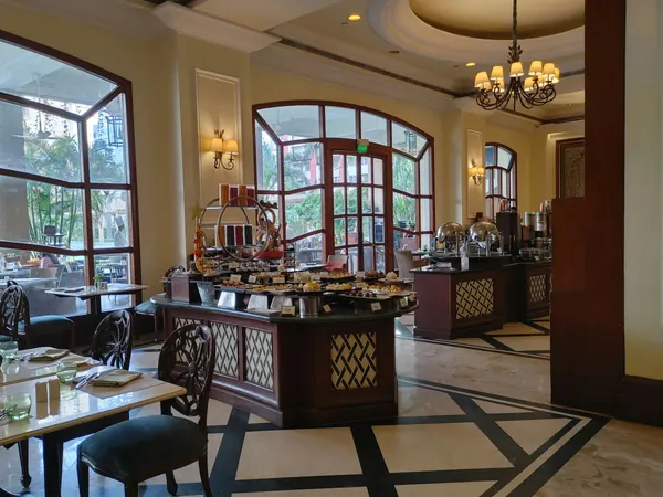 A hotel breakfast room with a buffet and tables