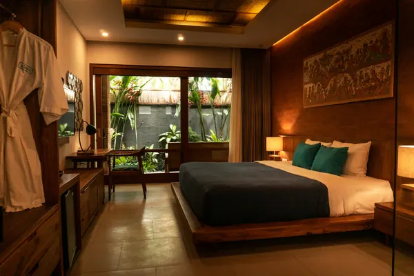 A hotel room with a large bed and wooden furniture
