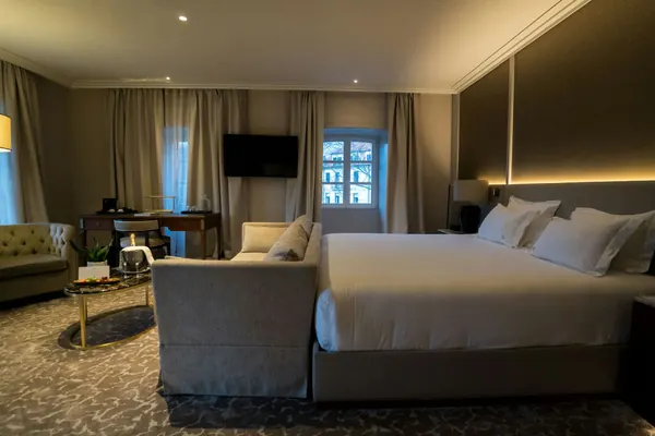A hotel room with a king bed and a sitting area
