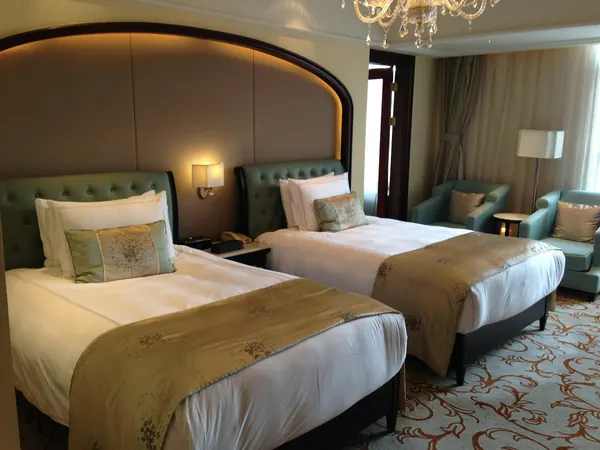 A hotel room with two beds and armchairs